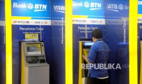  Warga melakukan transaksi menggunakan mesin ATM di bank BTN, Jakarta, Ahad (5/2).