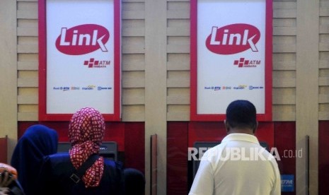 Warga melakukan transkasi menggunakan mesin ATM Himpunan Bank-Bank Milik Ngara (Himbara) di Pasar Tanah Abang, Jakarta, Ahad (9/10). 