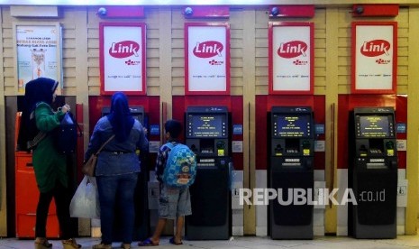 Warga melakukan transkasi menggunakan mesin ATM Himpunan Bank-Bank Milik Ngara (Himbara) di Pasar Tanah Abang, Jakarta, Ahad (9/10).