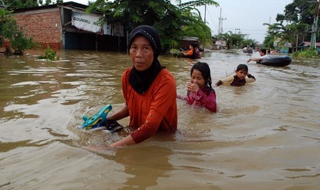 Warga melewati banjir yang merendam rumah di Desa Pulo Lawas Bangkinang, Kabupaten Kampar, Riau (Ilustrasi)