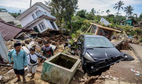 Warga melewati jalan yang rusak akibat gempa di Desa Sarampad, Kecamatan Cugenang, Kabupaten Cianjur, Jawa Barat, Selasa (22/11/2022). Gempa di Kabupaten Cianjur, Jawa Barat, mengakibatkan sejumlah rumah dan jalan rusak parah di Desa Sarampad. Akibatnya, kendaraan tidak bisa melintas untuk membawa bantuan bagi warga terdampak. 