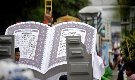 Warga melihat Alquran ukuran besar saat Pawai Pembukaan MTQ (Musabaqoh Tilawatil Quran) Banten ke-13 di Serang, Kamis (7/4). 