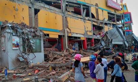 Warga melihat bangunan pusat perbelanjaan yang ambruk akibat gempa di Palu, Sulawesi Tengah, Sabtu (29/9).