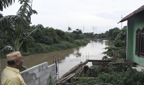 Warga melihat bangunan rumah yang amblas di bantaran Kali Bekasi, Jawa Barat, Rabu (20/1/2021). Badan Penanggulangan Bencana Daerah (BPBD) Kota Bekasi mengimbau warga yang tinggal di sekitar aliran kali untuk waspada banjir akibat kenaikan debit air Kali Bekasi karena curah hujan tinggi di wilayah Bogor.