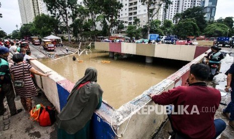 Warga melihat banjir yang menutup Underpass Kemayoran, Jakarta. Masyarakat diminta mewaspadai banjir yang terjadi di underpass atau jalan bawah tanah di persimpangan Jalan HBR, Motik Kemayoran, Jakarta Pusat, Selasa (25/2).