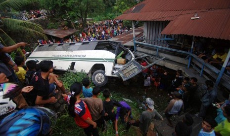 Warga melihat bus kampus Universitas Andalas (Unand) yang terguling di depan gerbang kampus tersebut, di Limau Manis, Padang, Sumatera Barat, Jumat (12/2). 