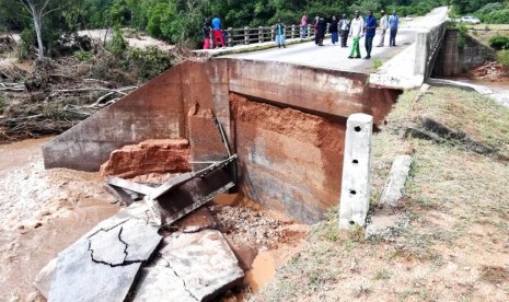 Warga melihat kerusakan di jembatan akibat Badai Idai di Chimanimani, Zimbabwe, Ahad (17/3).