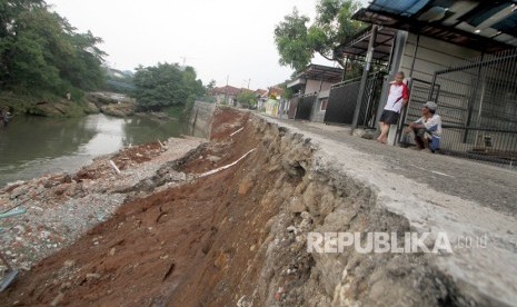 Warga melihat kondisi dinding penahan tanah atau turap yang longsor (ilustrasi)