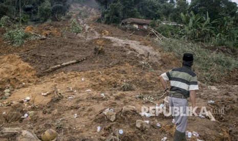 Warga melihat kondisi kawasan yang tertimbun material longsor di Desa Buninagara, Sindangkerta, Kabupaten Bandung Barat, Jawa Barat, Senin (5/3).