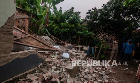 Warga melihat kondisi rumah yang rusak akibat gempa di Kadu Agung Timur, Lebak, Banten, Jumat (14/1/2022). Gempa berkekuatan 6,7 SR tersebut mengakibatkan sejumlah rumah rusak.