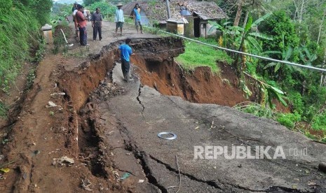 Warga melihat lokasi jalan antar kecamatan yang longsor di Selomanik, Kaliwiro, Wonosobo, Jateng, Selasa (30/1). 