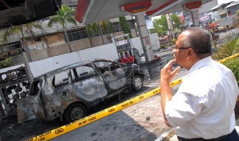  Warga melihat lokasi kebakaran yang menghanguskan sebuah mobil dan sepeda motor di SPBU.  