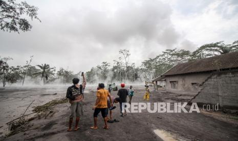 Warga melihat material awan panas erupsi Gunung Semeru yang mengalir di Sumber Wuluh, Lumajang, Jawa Timur, Ahad (5/12/2021). PVMBG mengeluarkan rekomendasi masyarakat/pengunjung/wisatawan untuk tidak beraktivitas dalam radius 1 kilometer dari kawah/puncak Semeru dan jarak 5 kilometer arah bukaan kawah di sektor Tenggara - Selatan, serta mewaspadai awan panas guguran, guguran lava, dan lahar di sepanjang aliran sungai/lembah yang berhulu di puncak Semeru. 