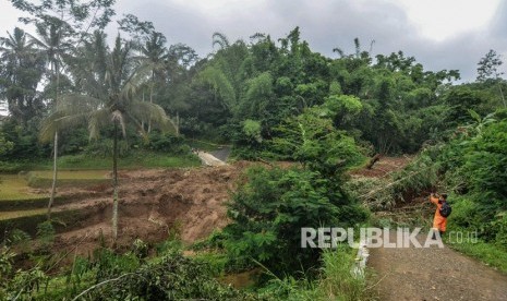 Warga melihat material tanah longsor yang menimbun jalan di Desa Santanamekar, Kecamatan Cisayong, Kabupaten Tasikmalaya, Jawa barat, Jumat (28/2/2020).