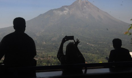 Warga melihat pemandangan Gunung Merapi di kawasan Magelang, Jawa Tengah, Kamis (20/6/2019).