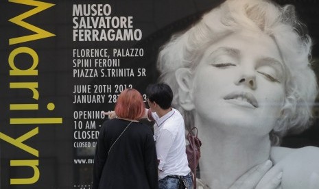 Warga melihat poster yang menampilkan gambar Marilyn Monroe di Tokyo, Jepang