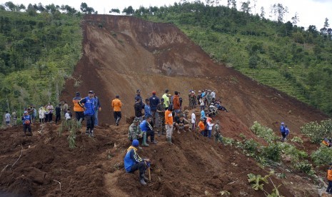 Warga melihat proses pencarian korban hilang tertimbun longsor di Desa Banaran, Ponorogo, Jawa Timur, Minggu (2/4). 