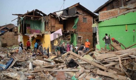 Warga melihat rumah tinggalnya dirobohkan oleh alat berat di permukiman padat di bantaran sungai Ciliwung di Kampung Pulo, Kampung Melayu, Jatinegara, Jakarta, Jumat (21/8). 