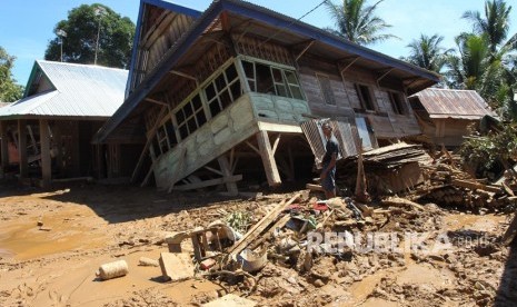 Warga melihat rumah yang ambruk karena diterjang banjir bandang (ilustrasi)