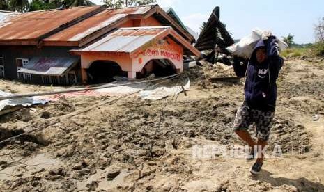 Warga melintas di area lokasi terkena gempa dan lumpur di Desa Sidera, Kabupaten Sigi, Sulawesi Tengah, Selasa (2/10).