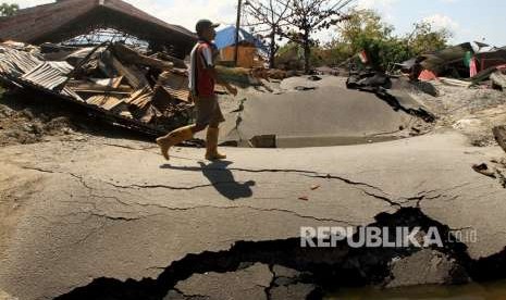 Warga melintas di area lokasi terkena gempa di Petabo, Palu Selatan, Sulawesi Tengah, Senin (1/10).