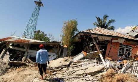 Warga melintas di area lokasi terkena gempa di Petabo, Palu Selatan, Sulawesi Tengah, Senin (1/10).