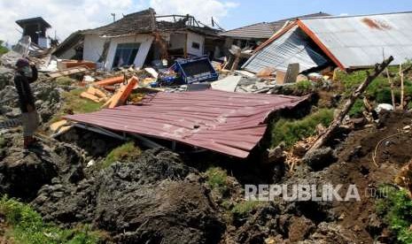 Warga melintas di area lokasi terkena gempa di Petabo, Palu Selatan, Sulawesi Tengah, Senin (1/10).