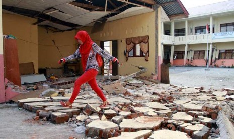   Warga melintas di bangunan SD Negeri 3 Ketol yang rusak parah akibat gempa di Desa Blang Mancung, Ketol, Aceh Tengah, Aceh, Jumat (5/7).    (Antara/Irwansyah Putra)