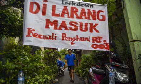 Warga melintas di dekat portal karantina wilayah di kawasan Tambora, Jakarta, Jumat (3/4). Presiden Joko Widodo menggelar rapat terbatas untuk mengevaluasi penerapan pembatasan sosial berskala besar (PSBB) di beberapa wilayah di Indonesia. Evaluasi dilakukan secara lebih detail untuk mengetahui kekurangan pelaksanaan PSBB.