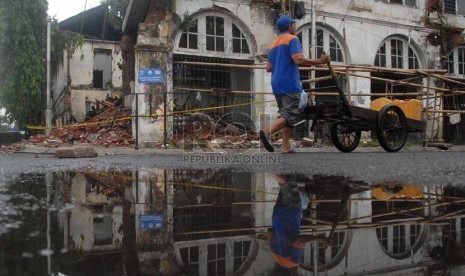 Warga melintas di depan bangunan tua yang ambruk di Kawasan Kota Tua, Jakarta Barat, Selasa (21/1).  (Republika/Rakhmawaty La'lang)