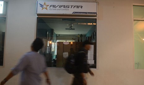 Warga melintas di depan konter Aviastar di Bandara Internasional Hasanuddin, Makassar, Sulawesi Selatan, Jumat (2/10). 