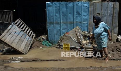 Warga melintas di depan rumah yang terdampak banjir bandang luapan Sungai Cipalebuh, Desa Mandalakasih, Pameungpeuk, Kabupaten Garut, Jawa Barat, Senin (12/10/2020). Banjir bandang tersebut mengakibatkan enam kecamatan di Garut Selatan terendam banjir.