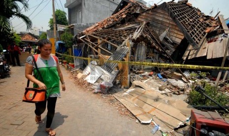 Warga melintas di depan sebuah rumah yang runtuh di kawasan pemukiman padat penduduk Jalan Batu Ceper VII, Jakarta Pusat, Selasa (22/10). (Republika/Rakhmawaty la'lang)