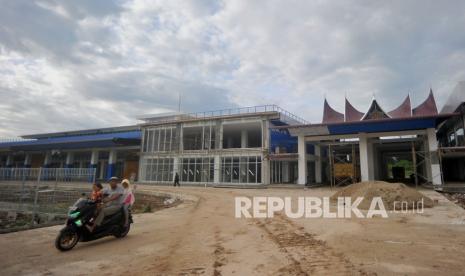 Warga melintas di depan terminal tipe A yang sedang dalam tahap penyelesaian pembangunan di Anak Air, Kecamatan Koto Tangah, Kota Padang, Sumatera Barat, Rabu (6/1/2021). Menteri Keuangan Sri Mulyani Indrawati meminta agar pemerintah tetap menjalankan berbagai program pembangunan infrastruktur di tengah pandemi Covid-19. 