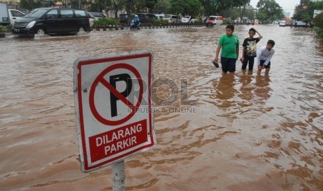   Warga melintas di Jalan Boulevard Barat, Kelapa Gading, Jakarta Utara, Jumat (17/1).  (Republika/Rakhmawaty La'lang)