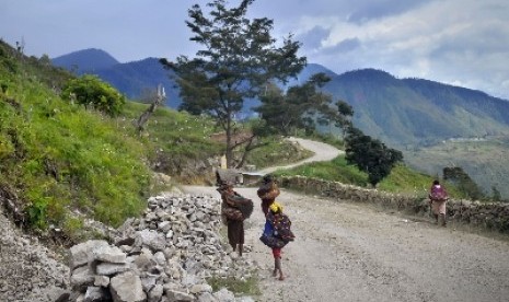 Warga melintas di jalan penghubung ke Kabupaten Lanny Jaya, Papua, Sabtu (5/3). 