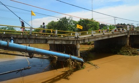 Warga melintas di jalan utama jembatan Putrapinggan, di Kecamatan Kalipucang, Kabupaten Pangandaran, Jawa Barat, Senin (10/10).