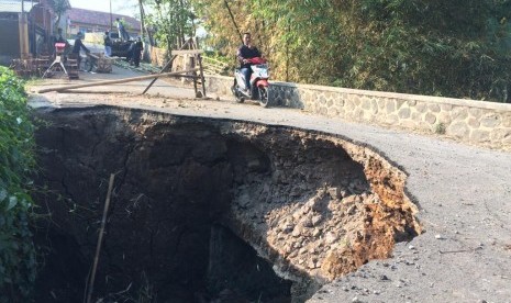  Warga melintas di jembatan amblas di Desa Karangsembung, Kecamatan Jamanis, Kabupaten Tasikmalaya, Rabu (14/8). Telah tiga bulan jembatan itu amblas tapi belum ada perbaikan hingga saat ini.