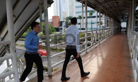 Warga melintas di Jembatan Penyeberangan Orang (JPO) di Jalan Rasuna Said, Jakarta, Kamis (26/11). 