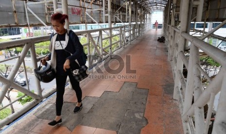 Warga melintas di Jembatan Penyeberangan Orang (JPO) di Jalan Rasuna Said, Jakarta, Kamis (26/11).