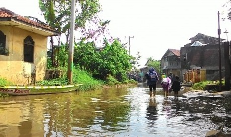 warga melintas di Kampung Cieunteung, Kecamatan Baleendah, Kabupaten Bandung, Kamis (26/11)