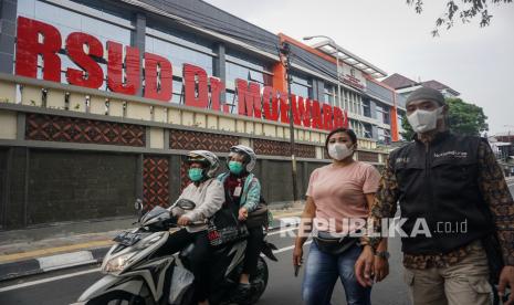 Warga melintas di kawasan Rumah Sakit Umum Daerah (RSUD) Dr. Moewardi, Solo, Jawa Tengah, Jumat (13/3/2020).(Antara/Mohammad Ayudha)