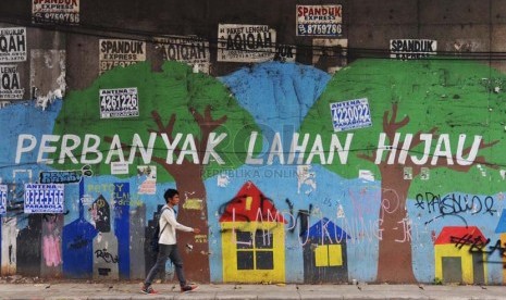 Warga melintas di samping mural yang bertuliskan 