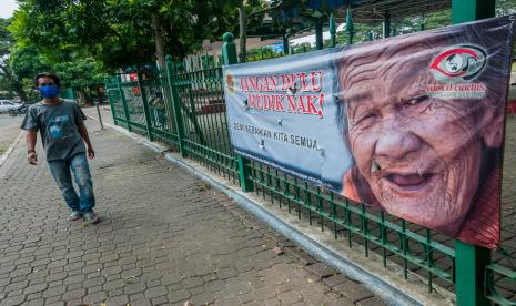 Warga melintas di samping spanduk imbauan tidak mudik di Rangkasbitung, Lebak, Banten, Senin (18/5/2020). Imbauan tersebut guna mengingatkan masyarakat agar tidak mudik demi memutus mata rantai penyebaran COVID-19. 