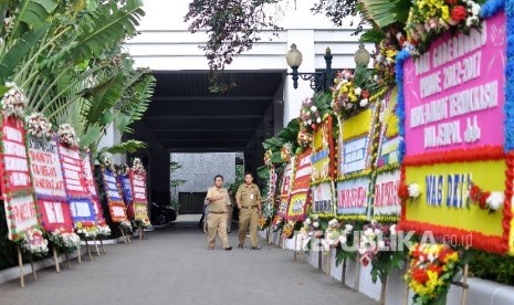 Warga melintas diantara karang bunga yang berisi ucapan terima kasih kepada Basuki Tjahaya Purnama dan Djarot Saiful Hidayat di Balai Kota DKI Jakarta, Senin (9/10).