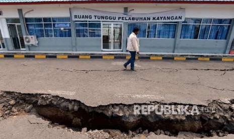 Warga melintas didekat area parkir ruang tunggu yang retak akibat gempa di Pelabuhan Kayangan, Lombok Timur, NTB, Selasa (21/8). Gempa bumi berkekuatan 7 skala ritcher yang mengguncang Lombok.