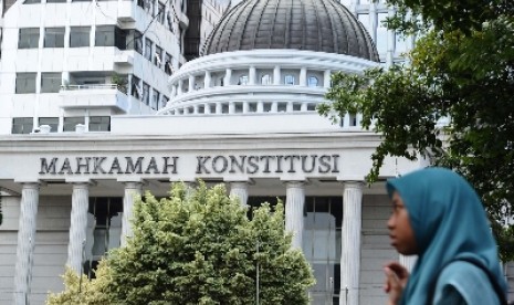 Warga melintas didepan gedung Mahkamah Konstitusi (MK), Jakarta, Ahad (11/1).