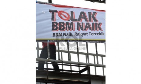 Warga melintas didepan spanduk penolakan kenaikan BBM di Jakarta, Jumat (7/6).  (Republika/Tahta Aidilla)