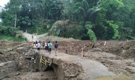 Warga melintas jembatan darurat di Desa Indrajaya, Kecamatan Sukaratu, Kabupaten Tasikmalaya, Senin (2/3). Jembatan utama yang berada di Desa Santanamekar, Kecamatan Cisayong, rusak terdampak longsor yang terjadi pada Jumat (28/2).