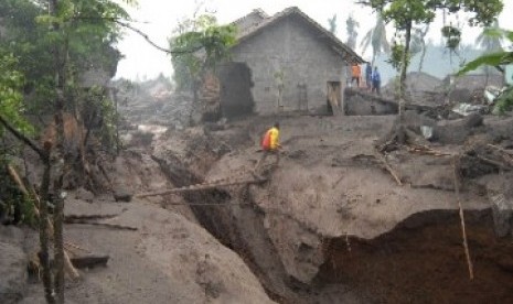 Warga melintas jembatan darurat diatas aliran baru sungai yang terbentuk akibat terjangan lahar hujan di Dusun Gempol, Jumoyo, Salam, Magelang, Selasa (4/1). Belum ada laporan korban jiwa dalam bencana yang menghantam perumahan penduduk.